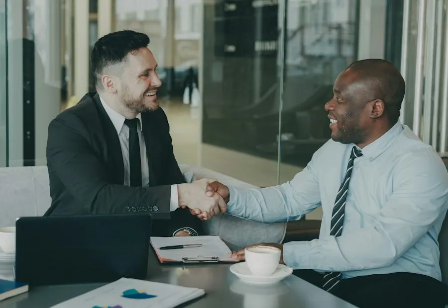 Two business people shaking hands across a desk